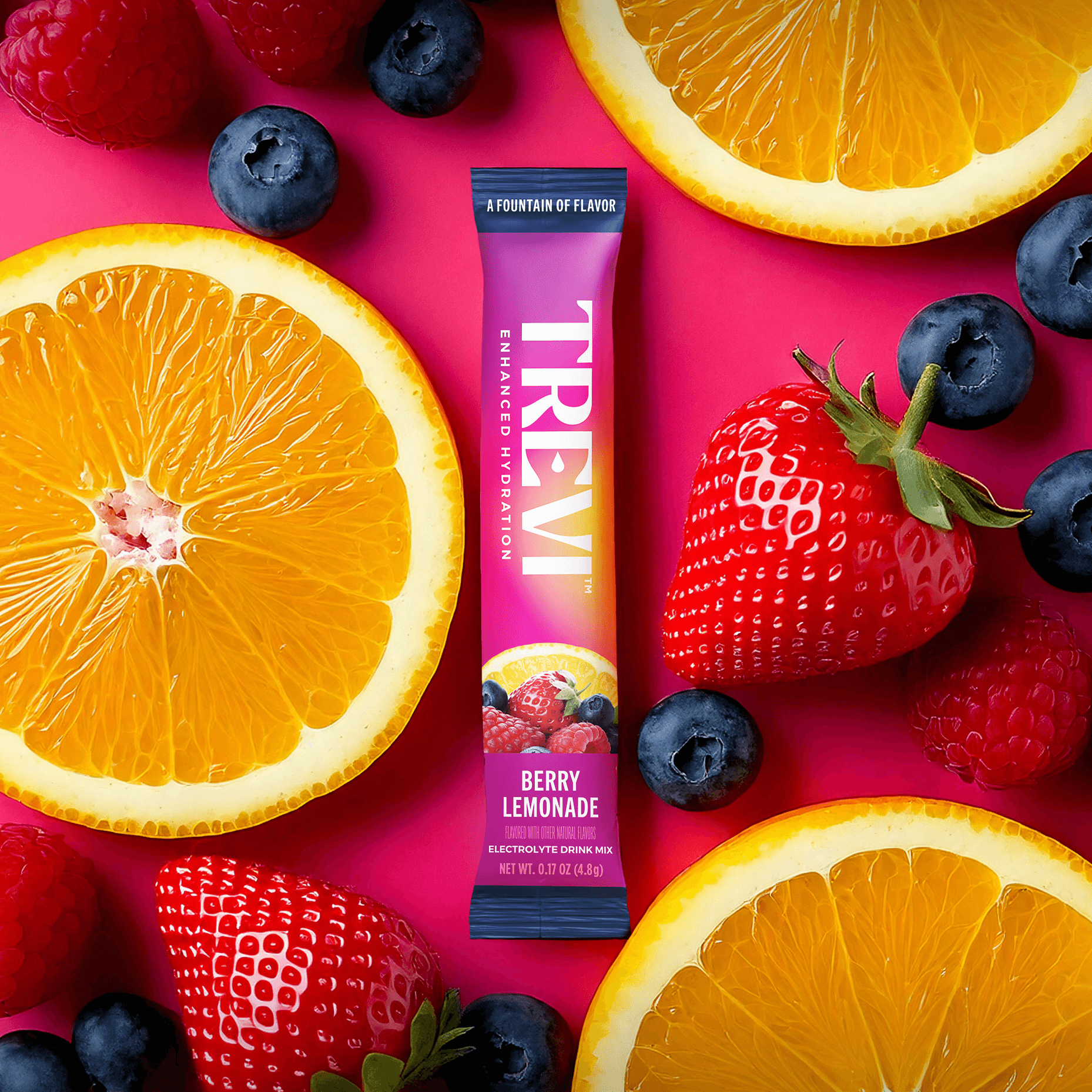Berry lemonade drink mix surrounded by fresh fruits on a pink background.